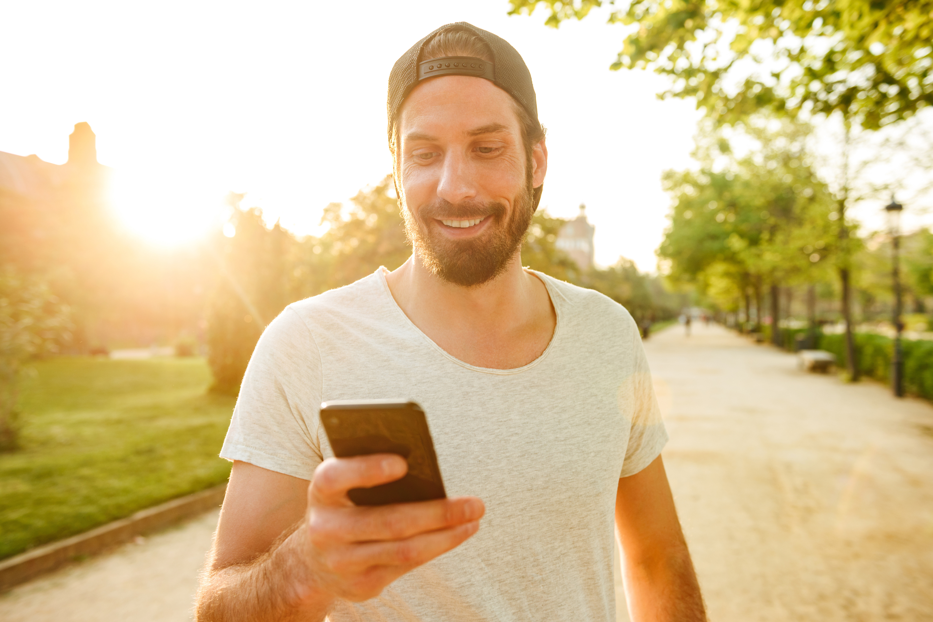 Man T-Shirt Backward Hat Park Mobile Phone