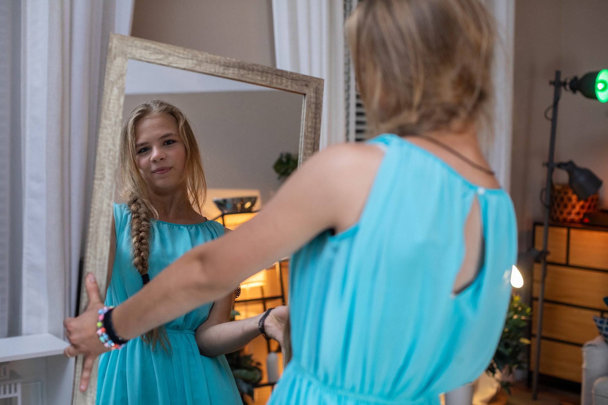 A teenager tries on a blue dress