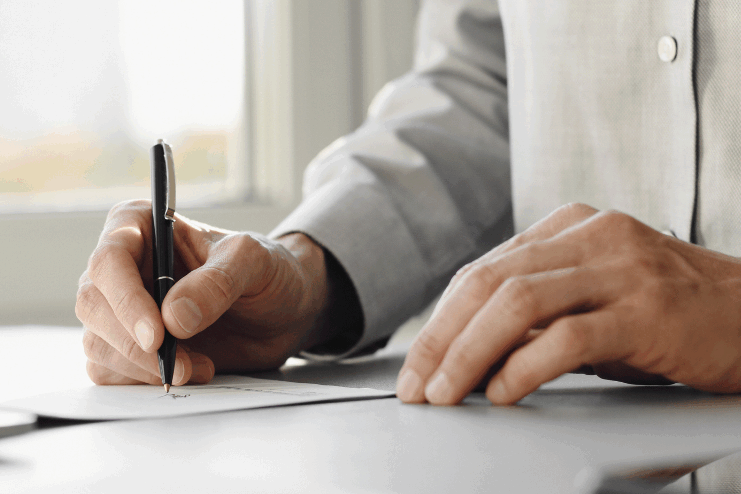 Stock image of man signing agreement.