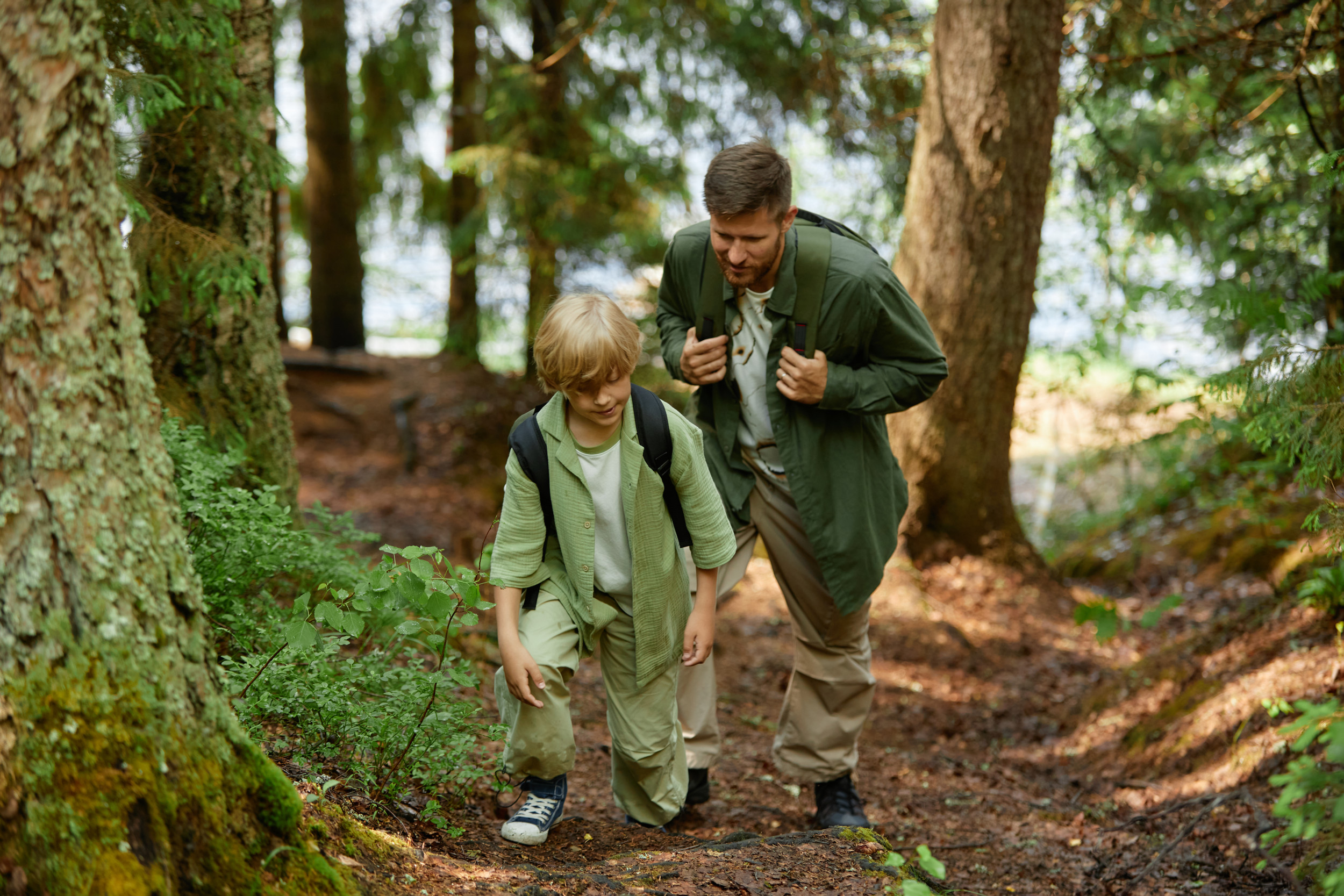 Man and child hiking in the woods.
