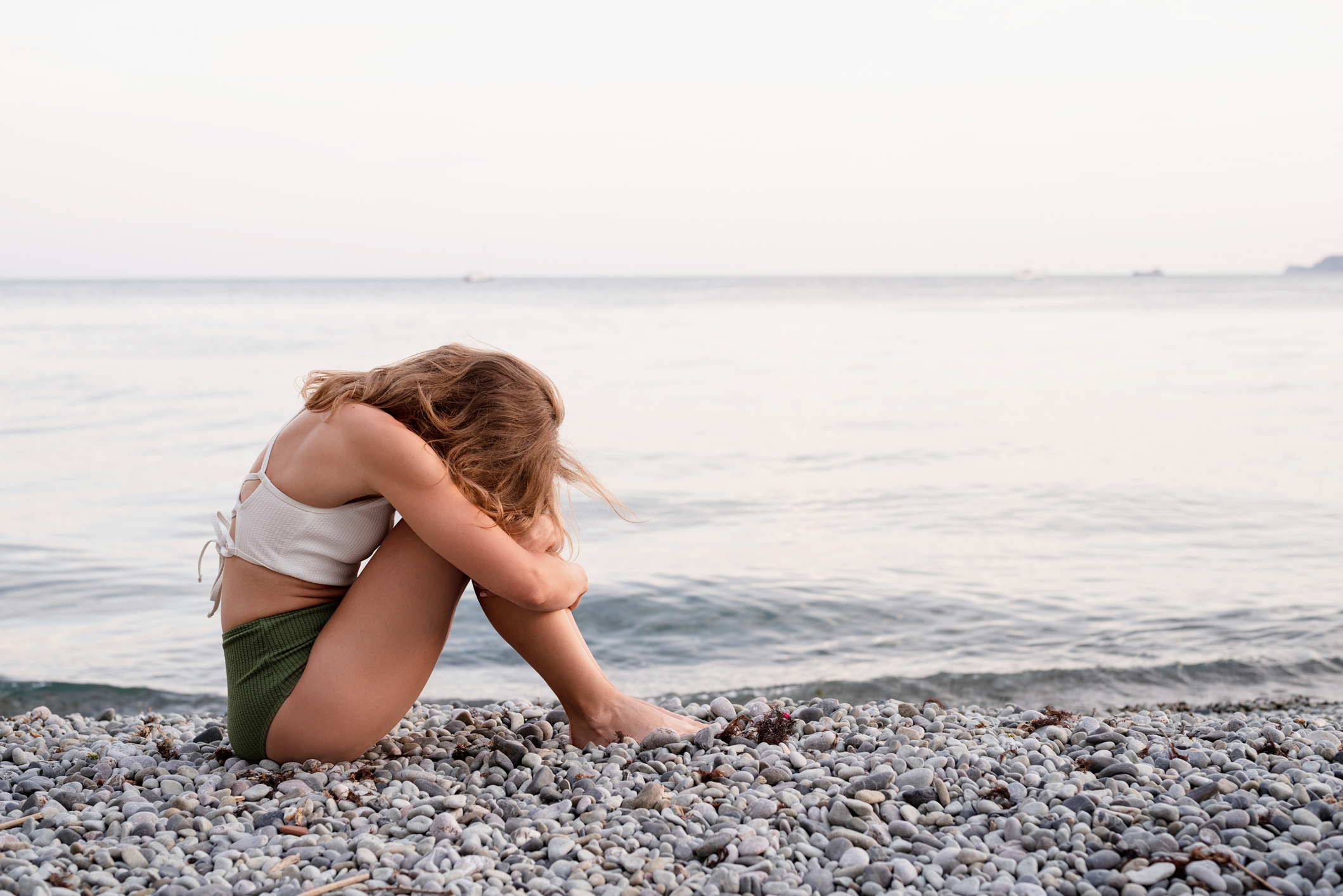 Stock image of sad woman on beach.